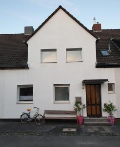 dos bicicletas estacionadas frente a una casa blanca en Home-Rose-Garden-Gästehaus kontaktloser Zugang en Düsseldorf