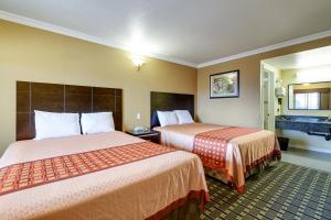 ein Hotelzimmer mit 2 Betten und einem Bad in der Unterkunft Hacienda Inn in La Puente