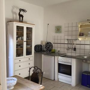 a kitchen with white cabinets and a table in it at FeWo Jacob in Garlstorf