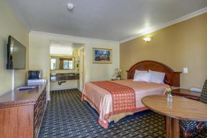 a hotel room with a bed and a table at Hacienda Inn in La Puente