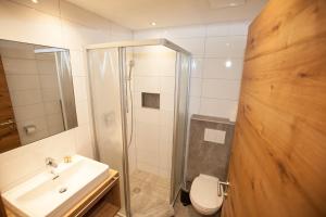 uma casa de banho com um chuveiro, um lavatório e um WC. em Haus Küchelspitz em Ischgl