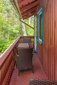 eine Terrasse mit Stühlen und Tischen auf einem Haus in der Unterkunft Apartamentai Geliu Vila in Nida