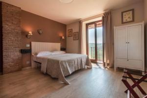 a bedroom with a bed and a large window at Poggio dei Farinetti in Diano dʼAlba