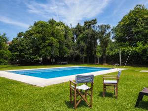 a swimming pool with two chairs and a table at Casa da Vinha in Arcos de Valdevez