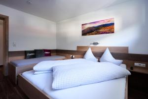 two beds in a room with white sheets at Apart Crystal in Längenfeld