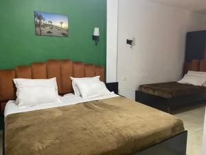 um quarto de hotel com uma cama grande e uma cadeira em Hotel Métropole Résidence em Tunes