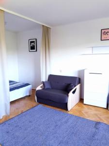 un soggiorno con divano blu e letto di Apartament SIELANKA PARK a Łódź