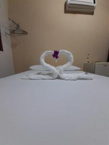 un cisne blanco hecho de toallas en una cama en Pousada da Pipa, en Pipa
