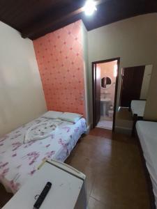 een kamer met 2 bedden, een tafel en een spiegel bij Pousada da Pipa in Pipa
