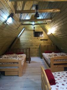 a attic room with three beds and a tv at Schwarz Kabin in Neagra