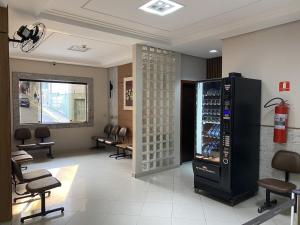 a waiting room with a drink cooler and chairs at Colina Park Hotel in Aparecida
