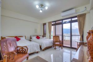 a bedroom with two beds and a balcony at 宜蘭樸實園民宿 in Jiaoxi