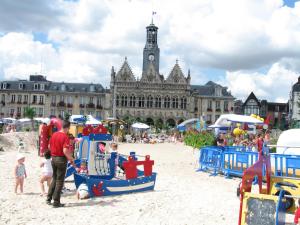 un groupe de personnes debout sur une plage avec une aire de jeux dans l'établissement Spacious Quentoinise Town House, à Saint-Quentin