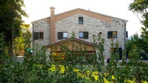 a stone house with a garden in front of it at Casa Giogano in San Leo