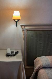 a lamp on a night stand next to a bed at Relais Ducale in Gubbio