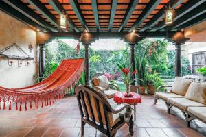 eine Terrasse mit einer Hängematte sowie einem Tisch und Stühlen in der Unterkunft Casa La Ermita in Antigua Guatemala