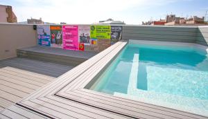 a swimming pool with a tub and chairs at Sant Jordi Hostels Rock Palace in Barcelona