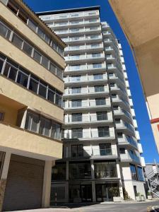 a tall apartment building with a parking lot at Holiday studio apartment near the beach and city centre in Gibraltar +3 photos