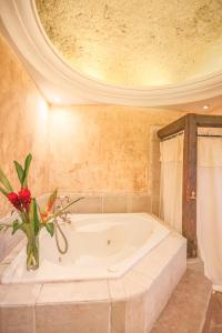 a bathroom with a tub with a vase of flowers at Casa La Ermita in Antigua Guatemala