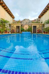 einem Pool mit blauem Wasser vor einem Gebäude in der Unterkunft Casa La Ermita in Antigua Guatemala