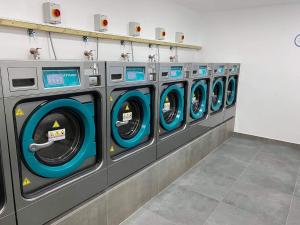 a row of washing machines in a laundry room at Holiday studio apartment near the beach and city centre in Gibraltar