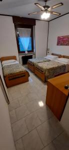 um quarto com 2 camas, uma mesa e uma janela em Hotel Isolabella em Bussoleno