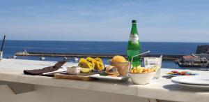 una mesa con una bandeja de comida y una botella de cerveza en Casa Chic, en Vila do Bispo