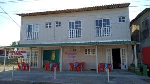 ein Gebäude mit roten Stühlen davor in der Unterkunft Pousada Solar di Poletti in Nísia Floresta
