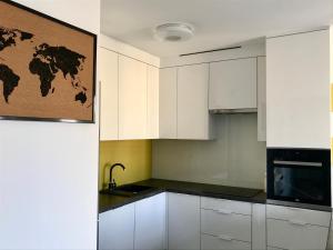 una cocina con armarios blancos y un mapa mundial en la pared en Apartament Julia en Skierniewice