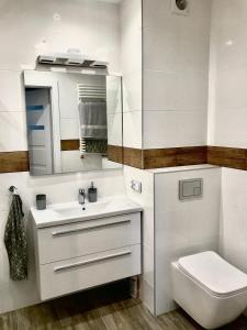 y baño con lavabo, aseo y espejo. en Apartament Julia en Skierniewice