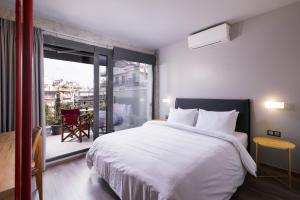 a bedroom with a large white bed and a balcony at Urban Donkey in Thessaloniki