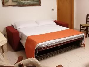 Un dormitorio con una cama con una manta naranja. en Casa Vacanze BORGO VECCHIO, en Scanzano Jonico
