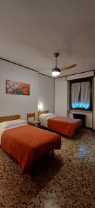 een slaapkamer met 2 bedden en een plafondventilator bij Hotel Isolabella in Bussoleno