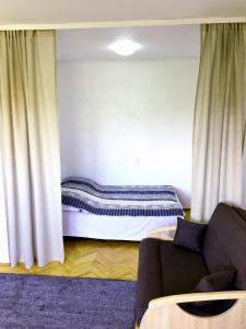 a room with a bed and a couch and curtains at Apartament SIELANKA PARK in Łódź