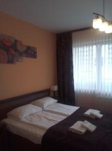 1 dormitorio con 1 cama con 2 toallas en Apartamenty Arka Medical Spa **** en Kołobrzeg