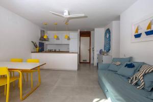 uma sala de estar com um sofá azul e uma cozinha em Domus Portisco em Marina di Portisco