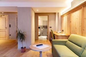 een woonkamer met een bank en een tafel bij Hotel Goldenes Roessl-adults only in Bressanone