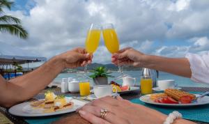 two people holding up glasses of orange juice at The Landings Resort and Spa - All Suites in Gros Islet