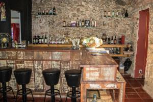 um bar com bancos numa sala com uma parede de pedra em Hotel Camboa Antonina - PR em Antonina