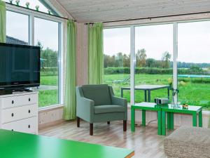 a living room with a tv and a large window at 10 person holiday home in Ansager in Ansager