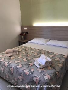 Ohana Apartments Camping Tiglio في سيرمِيوني: غرفة نوم عليها سرير وفوط