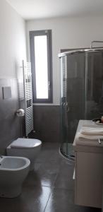 y baño con ducha, aseo y lavamanos. en Appartamenti porta mare en Otranto