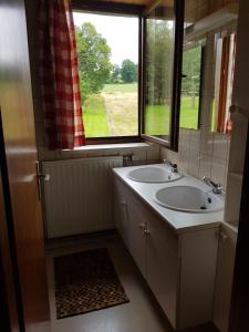 un bagno con due lavandini e una finestra di Raidillon - gîte 5 chambres a Malmedy