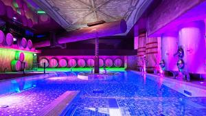 a swimming pool with purple and green lighting at Hotel SPA El Lagar de Isilla in La Vid y Barrios