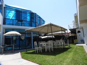 a group of chairs and umbrellas in front of a building at Arenas Hotel & Spa in Tacna