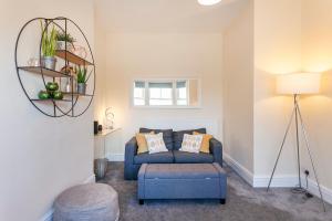 a living room with a blue couch and a mirror at Beautiful, Entire Luxurious One Bedroom Flat in Leicester