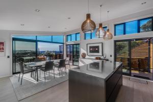 a kitchen and dining room with a table and chairs at Taonga with Sea Views by Waiheke Unlimited in Oneroa