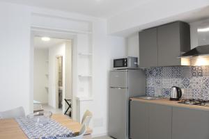 a kitchen with a table and a stainless steel refrigerator at Kasamare apartments in Cefalù