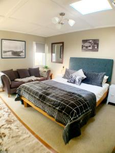 um quarto com uma cama grande e um sofá em The Little Red Shed em Russell
