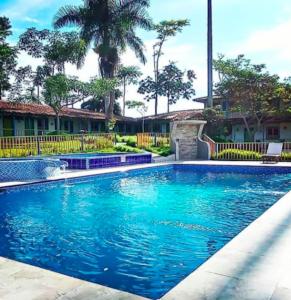 a swimming pool with blue water in a yard at Hotel Campestre Los Nogales in Quimbaya